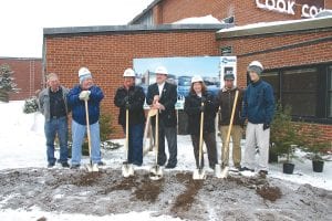 Construction crews had loosened up a patch of dirt outside the west wing of the Cook County Schools complex on December 10 in preparation for a groundbreaking ceremony for the Cook County Family YMCA. Under gray skies and snow, representatives from the Cook County Board of Commissioners, the Grand Marais City Council, Independent School District 166, the Duluth Area YMCA, and the Cook County Community Center Steering Committee as well as project architects and consultants threw shovelsful of dirt into the air. (L-R) Commissioner Fritz Sobanja, Grand Marais Mayor Larry Carlson, Commissioner Sue Hakes, Duluth Area YMCA Director Chris Francis, School District 166 Superintendent Beth Schwarz, Community Center Steering Committee Chair Paul Sporn, Commissioner Jim Johnson. “It’s been rough, but we’ve proved to the community that we can work together,” said County Commissioner Jim Johnson. A ribbon cutting ceremony and open house are expected to take place sometime next winter.