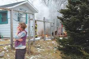 Amanda Hand anxiously watches as firefighters work to extinguish the fire in the mudroom of her home on Creechville Road on Tuesday, December 18. The blaze was contained to the storage room and no one was injured in the fire.