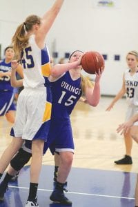 Above: Kaitlynn Linnell tried to put up a shot against Molly Trapp in the Vikings' game against Esko. At 6 feet tall, Kaitlynn looked small compared to Molly Trapp, and Molly is 5 inches shorter than her sister, Savanna. Right: Showing beautiful shooting form, Theresa Morrin just got her shot off over the outstretched fingers of the Esko player guarding her. The Vikings had a rough night against the Eskimos, losing 74-18.