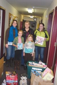 Standing in front of just a few of the bags of gifts distributed throughout the county for Christmas are (L-R, front) Paige and Taylor Everson. (L-R, back) Anna Sandstrom, Andrea Everson and MaeAnna LaFavor. (Not pictured, Lindsay Mielke.)