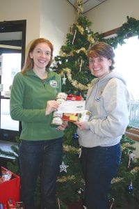 Tis the season for joyful giving! Deb Veit and Mary Hay of the North Shore Federal Credit Union display the nearly $3,000 check and some of the food items that were given to the Cook County Food Shelf as part of the credit union’s effort to bolster the Food Shelf’s depleted stores of items. The credit union matched the financial donations, said Hay.