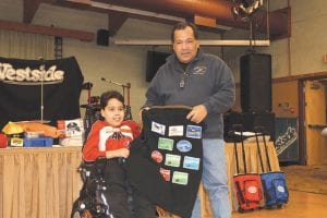 Left: Easter Seals Ambassador Zachary Pylychuk did a great job at the dinner for riders on Saturday night. He presented a special vest from Easter Seals, bearing the Grand Portage logo and 10 patches—one from each year the event has been held—to Grand Portage Tribal Chairman Norman Deschampe. Right: Despite the cold weather, riders were all smiles along the trails.