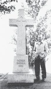 The man standing beside Father Baraga’s Cross is John Sayovitz of Ely, Minnesota. The photo was taken on Easter 1955. According to his grandson, Mike Koski of Ely, many Slovenians from Ely would make trips to the cross where their compatriate, Father Frederic Baraga, and a Native guide made a safe landing after a treacherous trip across Lake Superior in 1846. They set up a cross in thanks to God before making their way to Grand Portage to help with an epidemic. The original cross was eventually memorialized with this one.