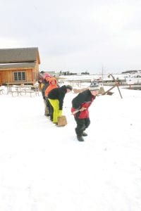 Left: Adrian Howard-Larsen pulls four classmates on his toboggan. Hansen wanted the kids to learn how hard it was to pull a toboggan loaded with weight for even a small distance.