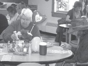 Grand Portage Elders had a great February. Above: On Valentine’s Day there was a special bingo. Ellie Olson was quite serious about her daubing. Left: Elder Judy Ranta, the Grand Portage Community Center director, has been having fun working with young girls teaching them to cook.