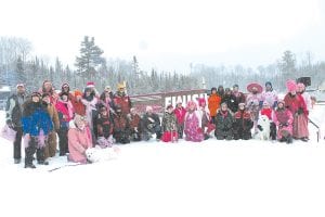 Pretty in pink! The 2013 Mush for a Cure was held March 8-9 and all of the mushers and dogs looked wonderful in pink. Leading them was Jessica Berg-Collman (above left) of Grand Marais, who was first across the finish line on Poplar Lake. Jessica was also one of the top fundraisers in the field of 40 mushers who gathered for a photo in the snow that started falling at the end of the race. There were mushers from all over the U.S., as far as Washington State, New Jersey and even Louisiana!