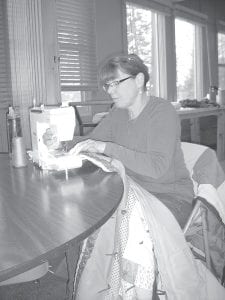 Former consumer and family science teacher Cindy Muus used her considerable expertise at the sewing machine to help stitch quilts for refugees in a quilting bee at Bethlehem Lutheran Church on March 8.