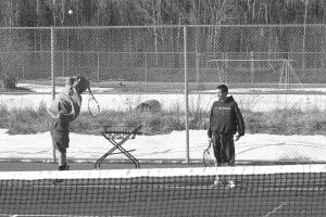 With no indoor facility to practice in, the Cook County high school boys' tennis team is practicing outside in the wind and cold, dodging occasional snowflakes as they chase tennis balls down. Here Jamie Wick serves while Pete Summers looks on. The boys' first match will be held at Duluth East on April 13, and while snow is predicted for this weekend, the long-range forecast suggests the Northland will be slowly warming up.