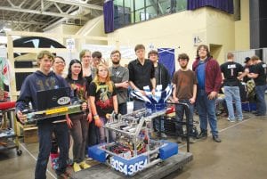 Above: The Cook County High School Robotics team— Ice Storm—with their creation at the DECC in Duluth. (L-R) Nate Carlson, Casey Deschampe, Kaylee Danielson, Cedar Adams, Clara McNealy, Bergen Keller, Industrial Technology teacher Sam West, Alec Nielson (mentor), Alton Danielson (mentor), Carl Ingebrigtsen (mentor), Brandon Bockovich. Left: Ice Storm in action! The robot built by Cook County High School students successfully tossed a Frisbee during competition.