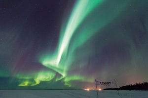 Top: The Hudson Bay Quest is an arduous adventure, but it has its benefits, such as the amazing aurora borealis that light the sky. 10 Squared Racing dog handler Nace Hagemann of Grand Marais spent much of the trip photographing the ever-changing Northern Lights. Above: Musher Matt Groth gives a thumbs up in celebration of finishing in 5th place in the challenging race.