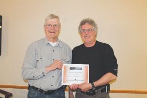 Cook County Emergency Management Director Jim Wiinanen (left) presents Michael Valentini of the Gunflint Trail Fire Department with the Emergency Services Provider of the Year Award for 2013. Valentini was nominated by Gunflint Fire Chief Mike Prom. Valentini accepted the award on behalf of his colleagues on the Gunflint department. “We all do this together,” he said.