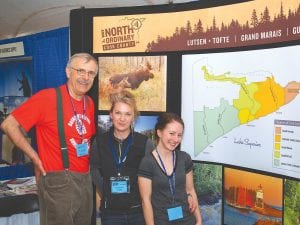 Martin Kubik of the Boundary Waters Advisory Committee visited with Cook County Visitors Bureau representatives at the Midwest Mountaineering Outdoor Adventure Expo in April. (LR) Kubik, Anna Klobuchar, Shelby Gonzales. Kubik quipped, “Up at Cook County where women are smart, beautiful and strong.... and where men like to be photographed with them.”