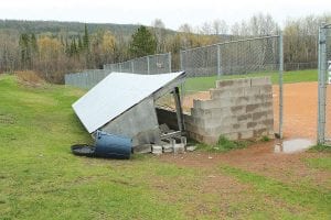 After the high winds during the night of Sunday, May 19, 2013, Cook County residents awoke to trees down across driveways and trash cans blown away. Several businesses—such as the Birch Terrace in Grand Marais—had signs toppled. The Pappy Wright Little League Field saw significant damage. The high winds caught the roof of one of the dugouts, peeling it back and causing the cinderblock walls to collapse. Baseball season has begun, so it will be a challenge for the teams to play without two intact dugouts. Since volunteers originally constructed the dugouts, it is not yet known how and when the dugout will be rebuilt.