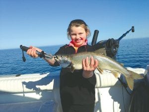 Katie Peck, 8, of Tofte caught the first lake trout of the season aboard Tofte Charters. She had a little help from her dad, Captain Darren Peck.