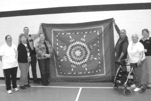 A number of Grand Portage people went to the Elder Abuse Conference recently in Hinckley, MN. Julie Black Elk won this beautiful star quilt at the conference and she gave it to the ENP. The quilt will hang in the Community Center gym alongside the Wisdom Steps blanket and flags. (L-R) Shirley Stevens, Ellen Olson, Deputy Greg Gentz (behind), Patty Winchell-Dahl, Diddo Swader, Bernice Legarde, Julie Black Elk. Not pictured: Betty Hoffman.