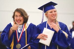 Above: Mara MacDonell and Cailan Carpenter, diplomas in hand, celebrate as they exit the gym. Valedictorian Mara’s final words to her classmates? “We did it!” Left: Salutatorian Katie Vander Heiden was all smiles with her diploma as well.