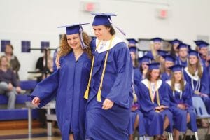 Michaela Peterson (left) and Sarah Larsen head to the microphone to sing an original piece of music at the Cook County High School commencement exercises on June 1, 2013. The song, Hello World, was written by Peterson and local musician Laura Laky especially for the graduation ceremony. See more graduation news on page A3.