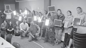 Members and leaders of Cook County’s IMPACT team hold up solar panels that they will be donating to a village in Kenya. The panels will replace kerosene lanterns that cause respiratory illness and fires. IMPACT teaches kids to serve in ways that help them solve problems found both abroad and locally. There are about 15 teens involved with the program which is run by Coldwater Foundation.