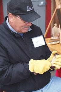 Left: North House carving instructor Bruce Futterer puts the finishing touches on a bearded face. Futterer was one of the artisans braving the chilly weather on the commons. Above left: Jarrod Stehahl demonstrated the craft of wooden spoon making. Above right: Brightening the foggy day were Karen Rognsvoog’s scarves, created using natural plant dyes.