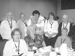 Above: Grand Portage Elders learned a lot and had a lot of fun at the Wisdom Steps Conference in White Earth June 11 – 13. At the awards banquet, Elvis put in an appearance. (L-R, front) Doris Blank, Carol Hackett, Vera Amyotte. (L-R, back) Carol Conrad, Dottie Griffith, Bernice LeGarde (getting a hug from Elvis!), Jaye Clearwater, Johnie Barton. Left: The karaoke performance in the evening at the Mustang Lounge was also fun. Carol Hackett was serenaded by one of the local performers.