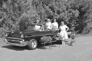 Grand Marais Garden Club members don ’50s attire to announce the theme of the 2013 flower show: Rock ’n Flowers. Pictured in the flashy ’50s convertible, courtesy of Pete and Carline Gresczyk, are Chairperson Kathy Siesennop, driver; Sally Berg and Jan Healy, seated in the car; Jan Attridge on left and Skip Joynes, standing.