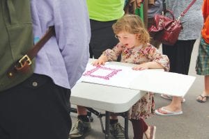 Above: Visitors were able to screen-print their own T-shirts at the Grand Marais Art Colony booth. Little Esme was delighted with her creation.