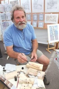 Above left: David Steckelberg of Grand Marais created book markers while visiting with the crowds. He sketched exquisite renderings of birch trees with India ink on slips of birch bark. Left: There was the smell of freshly-turned wood at the booth of Cooper Ternes of Northern Wooden Wares.