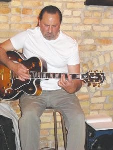 Left: Jazz guitarist Briand Morrison of Grand Portage performed June 15, 2013 at the Donaldson Hotel in Fargo, North Dakota prior to the opening of a two-year crosscountry exhibit of the work of his father, the late artist George Morrison. Above: Morrison’s 1949 watercolor and crayon piece, Sun and River, includes the distinctive horizon line that was characteristic of his work.