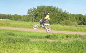 A number of local families enjoy dirt bike racing. Top: Jacob Smith, 9, spends hours practicing on the little track at his house before heading to Echo Valley Motocross Park for the real thing. Above left: Devin Smith started racing when he was about Jacob’s age. He continues to enjoy the sport and has the trophy to prove it! Above right: Jacob Smith was all smiles after the first race of the season where he earned a 3rd place trophy.