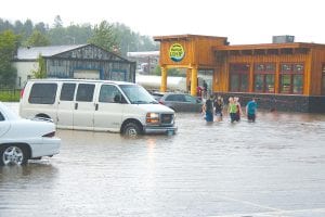 Torrential rains topping 5 inches in some Cook County locations inundated the municipal parking lot in downtown Grand Marais July 18, 2013. Although several vehicles parked in the lot were stranded until the water receded later in the evening, the high waters did not deter determined shoppers and thrill-seekers from making their rounds. Fortunately, the newly remodeled Whole Foods Co-op building was designed to withstand the occasional flooding and remained open to customers throughout the day.