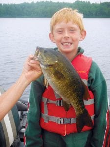 Left: Will Sorensen of Neenah, Wisconsin caught this impressive 18-inch bass while fishing with Joe Carlson of Joe’s Inland Guide Service. Will was visiting his aunt, Mary Sorensen.