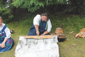 During Rendezvous Days, the Grand Portage National Monument offers a glimpse of life at a fur trade depot in the late 1700s. Right: Kiri Butter of Thunder Bay stitches birch panels for a structure in the monument’s Ojibwe village.