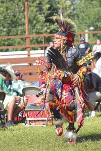 Grand Portage Powwow emcee Murphy Thomas encourages participants to “Dance your style!” This young man added a Marine Corps flag to his regalia and followed Thomas’s instructions.