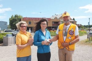 The lucky winner of the Grand Marais Lions Club Fisherman’s Picnic raffle grand prize of $10,000 was Bonnie Goebel of Grand Marais and Burnsville, Minn. Goebel was not in Grand Marais when her winning ticket was drawn, but she and her husband Hardy Goebel were back in town this week. They were quite happy to meet the Grand Marais Lions in Harbor Park to accept their prize. (L-R) Lioness Sally Hennessy, Bonnie Goebel, and Lions Club President Bill Hennessy. Goebel was happy to see Hennessy again—he is the Lion who sold her the winning ticket!