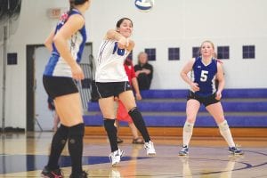 While Breanna Peterson (foreground) and Anna Carmen (No. 5) watch, Sarah Deschampe takes a hard serve and bumps it to the front line to set up a play in the Vikings' game against the Duluth Marshall Hilltoppers. The Vikings beat the Hilltoppers 3 games to 1 in their season opener.