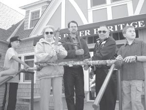 There were numerous celebrations in Schroeder as work on the Cross River Heritage Center progressed. There was a ceremony with the Minnesota Department of Transportation when the historic Stickney store was deeded to the Town of Schroeder in 2001. There were gatherings every year during John Schroeder Days until the official opening of the heritage center in 2003. Pictured here are founding members of the Schroeder Area Historical Society Margaret and Kermit Carlsen doing the honors at the 2003 event—sawing a log instead of cutting a ribbon! Between Margaret and Kermit is Tim Dickenson, representing his mother, Carolyn Miller. The young boys watching are Ryan Martinson (left) and Jesse Johnson (right).