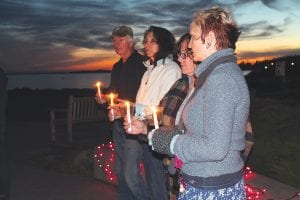 About 30 people gathered in Harbor Park in Grand Marais on Tuesday, October 8 to take part in a candlelight vigil remembering the people who perished in domestic violence incidents this year. Participants in this Domestic Violence Awareness Month event were deeply saddened to hear that the number of people who had died has risen drastically this year. To date in 2013, 23 people in Minnesota have been killed by a spouse or intimate acquaintance. In the beautiful, deepening twilight, those gathered remembered those lost and expressed hope that someday such gatherings will not be needed.