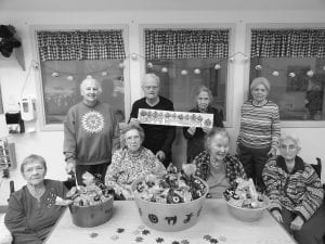 Residents at the North Shore Care Center were busy filling treat bags for the annual Halloween Party at the Community Center last week. Residents loaded 260 bags full of goodies! (L-R, front) Joyce Kehoe, Irma Larsen, Janet Morgan, Eleanor Matsis. (L-R, back) Phyllis Kettunen, Whitey Dockan, Trudy Boyd, Marie Jacobson.