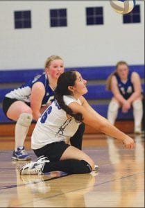 Left: With Anna Carman urging her on, Sarah Deschampe hit the floor to “dig” the ball and set up her teammates in the frontcourt. Above: Breanna Peterson went up high to spike the ball in a recent game.