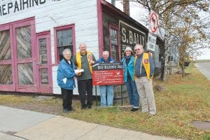 Members of the Cook County Historical Society (CCHS) met at the Bally Blacksmith Shop to accept a donation from the Grand Marais Lions Club last week. The Lions contributed $5,000 toward restoration of the old building. (L-R) CCHS Treasurer Eleanor Waha, Lions Club President Harry Peterson, CCHS Chair of Finance Hal Greenwood, Museum Director Carrie McHugh, Lion and CCHS President Gene Erickson.