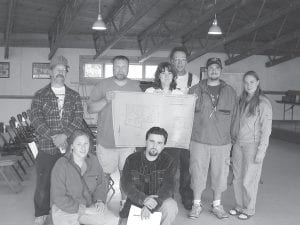 This photo shows the successful applicants in the Schroeder land lottery, held Saturday, June 22, 2002. They became landowners in the 90-acre Fredenberg Creek Estates subdivision, which was developed by the town of Schroeder. The project began with a donation of land from LTV Steel Mining in 1989. An $80,0000 grant from the Iron Range Resources Rehabilitation Board (IRRRB) covered expenses for road construction, surveys, wetland delineation and contractor costs. The township invested approximately $19,000 in the land. The goal of the township was to sell the land to families that will remain in Schroeder, living and working in the community. Lot prices ranged from $7,000 to $12,000. After the Schroeder land lottery on Saturday, successful applicants took another look at the map of their land. (L-R, front) Abby Derix, Aleksey Golubev. (L-R, back) Kelly Schliep, Paul Trogden, Angela Cook, Scott Waterhouse, Waylon Christensen and Lynn Heinzen. (Not pictured Peter Borson)