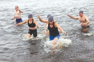 If all your friends jumped in the lake, would you? Apparently, for 36 people, the answer is “yes!” As part of the inaugural Lake Superior Storm Festival, a Wave Dash was held on the beach of Lutsen Resort. Above: Cook County Visitors Bureau Director Linda Kratt and friends rush back to shore. Left: Mary Sue Stothart of Blaine, Minn. and Julie Edwards of Chicago, Ill. traveled a long way to catch a wave. The money raised goes to the Cook County Community YMCA for swimming lesson scholarships and the local food shelf.