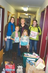 It takes a lot of helpers to gather, wrap and distribute Christmas gifts to those in need, and once again a team of volunteers is taking on the task. (L-R, front) Paige and Taylor Everson. (L-R, back) Anna Sandstrom, Andrea Everson, and MaeAnna LaFavor will be part of Operation Family Christmas.