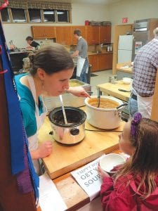 Above: “Would you like this kind of soup?” Maren Webb asks this little girl who was weighing her options. Webb was one of many volunteers who helped make Empty Bowls a tremendous success again this year. Right: With many beautiful bowls on display, Tara Block was on hand to help people make their difficult selection.