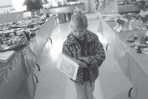 Above: Among all the Christmas goodies at the North Country Creations Bazaar at the Schroeder Town Hall were fairy doors, an item this little girl really, really, wanted. Left: Al Sunde’s holiday wood carvings are another delightful item at the town hall.