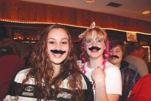 Silly moustaches in keeping with the Italian bistro theme were sold as part of the fundraiser. Wellesley Howard-Larsen and Kya Brazell model theirs.