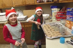 Girl Scouts were busy being elves at Santa’s Workshop at the First Congregational Church on Saturday. Junior Scouts RaeAnne Silence and Anna Hay get a tray of sausages ready for the delicious pancake breakfast that was served to shoppers.