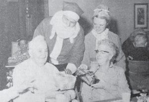 Santa and Mrs. Claus, in the person of Victor Anderson and Danette Rainwater, distribute gifts to Bernt Everson and Olive Schuyler, residents of the Cook County Nursing Home. This Dec. 21, 1972 photo was taken at the Hospital Auxiliary Christmas party, which was organized by Kaye Rosenthal, occupational therapist. Besides the 40 residents and their families, the doctors and nurses were invited to join in the festivities.