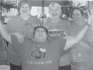 Top: Grand Portage Elder Nutrition Program staff were treated to silly holiday T-shirts by ENP Director Patty Winchell Dahl. Showing off their festive attire is (L-R) Polly James, Carol Hackett, Shirley Stevens and seated, Cedar Denny. Above: Everyone had a great time at the Elder’s Christmas Party at the Grand Portage Lodge on December 8, including Bernice LeGarde and her brother, Herman Hendrickson.