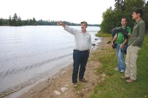 Above: Duluth Metals Senior Vice President of Exploration Dean Peterson, Ph.D., stands on a beach at the Kawishiwi Lake Campground, talking to the press. Left: Sulfide-bearing bedrock outcroppings such as this that have been weathered from exposure to air and water can be found in spots throughout the Duluth Complex – in and around the Boundary Waters Canoe Area Wilderness, along the Gunflint corridor and along Highway 61. “The chemistry of the nearby streams indicates that natural weathering is an ongoing process,” said Duluth Metals Senior Geologist Phil Larson, Ph.D. “The gravelly material surrounding the boulder…forms from the breakdown of coarse crystalline rocks by chemical weathering.”